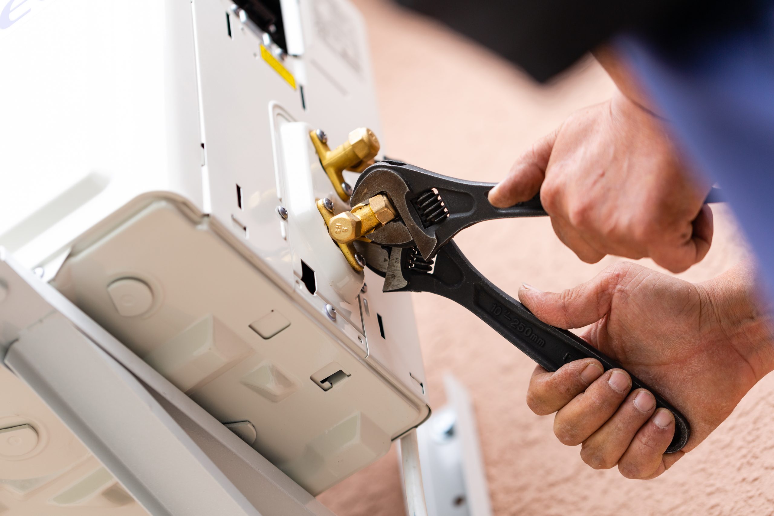 Tools and instruments. Male repairman works using two adjustable wrenches at once. Close up of connecting parts when installing air conditioner. DIY concept.