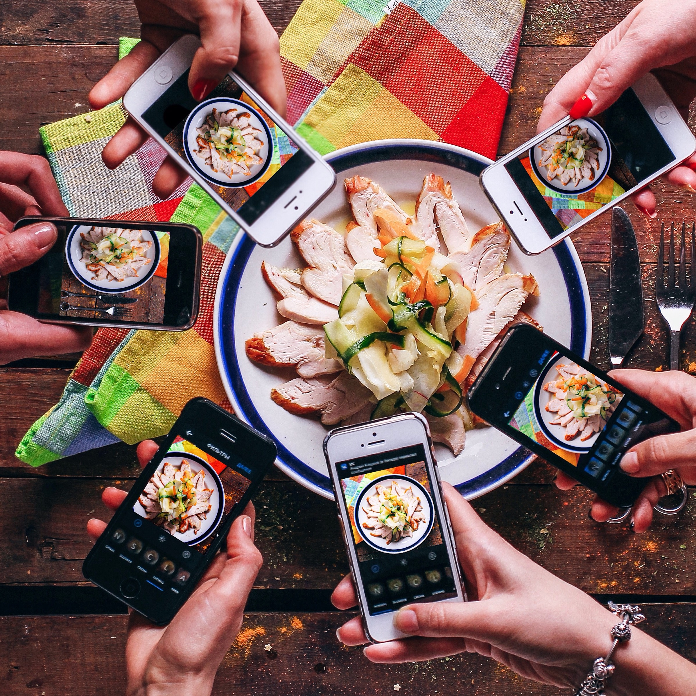 Mobile phone in hands ,people take photos of tasty food top view , food porn and technology, socal networks